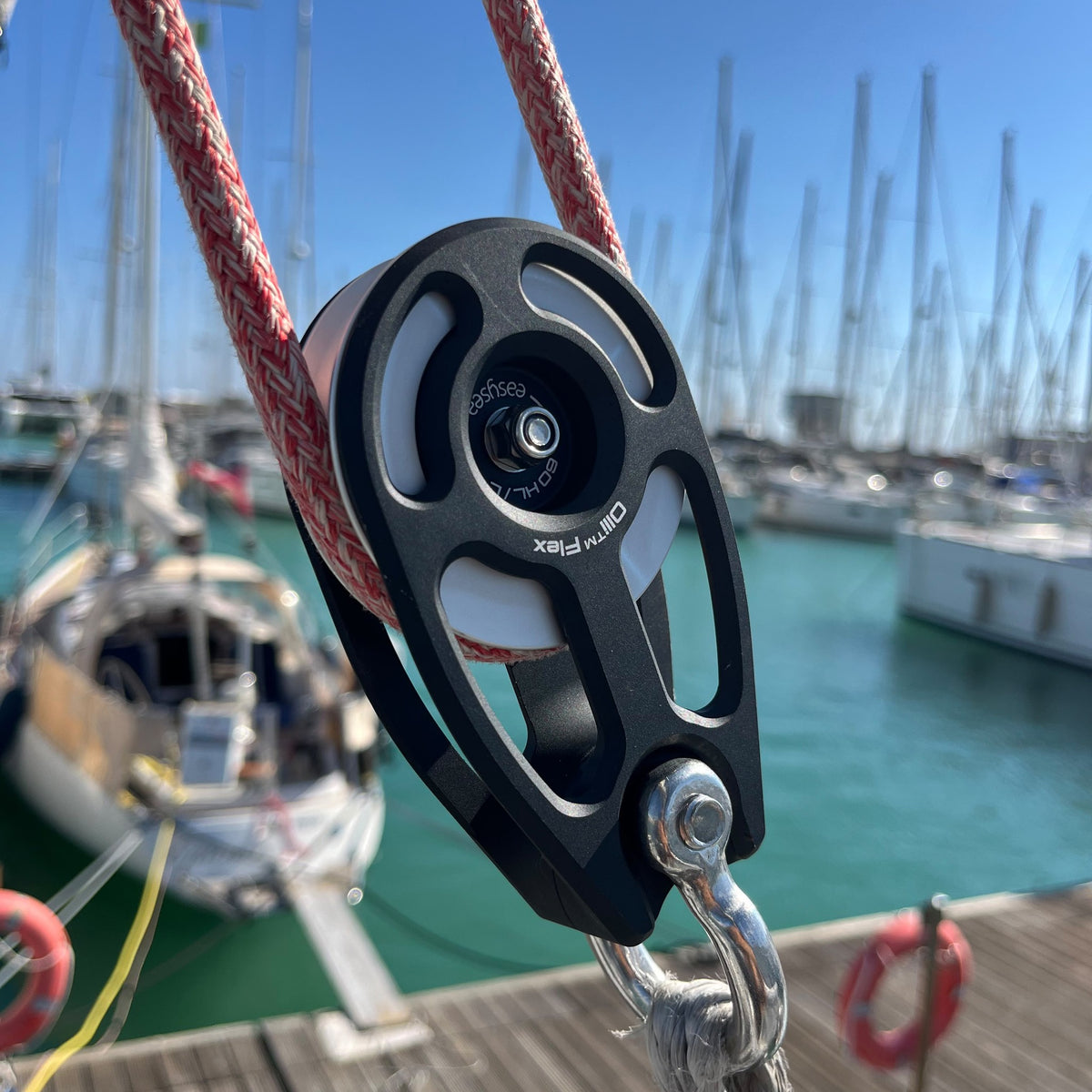 Easysea Olli Flex HL 60 L black modular block in use on a sailboat, hanging on a soft shackle with the sheet running through