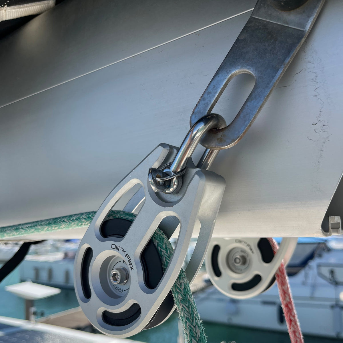 Easysea Olli Flex 60 L modular block mounted under the boom of a sailboat, close-up with sheets running through