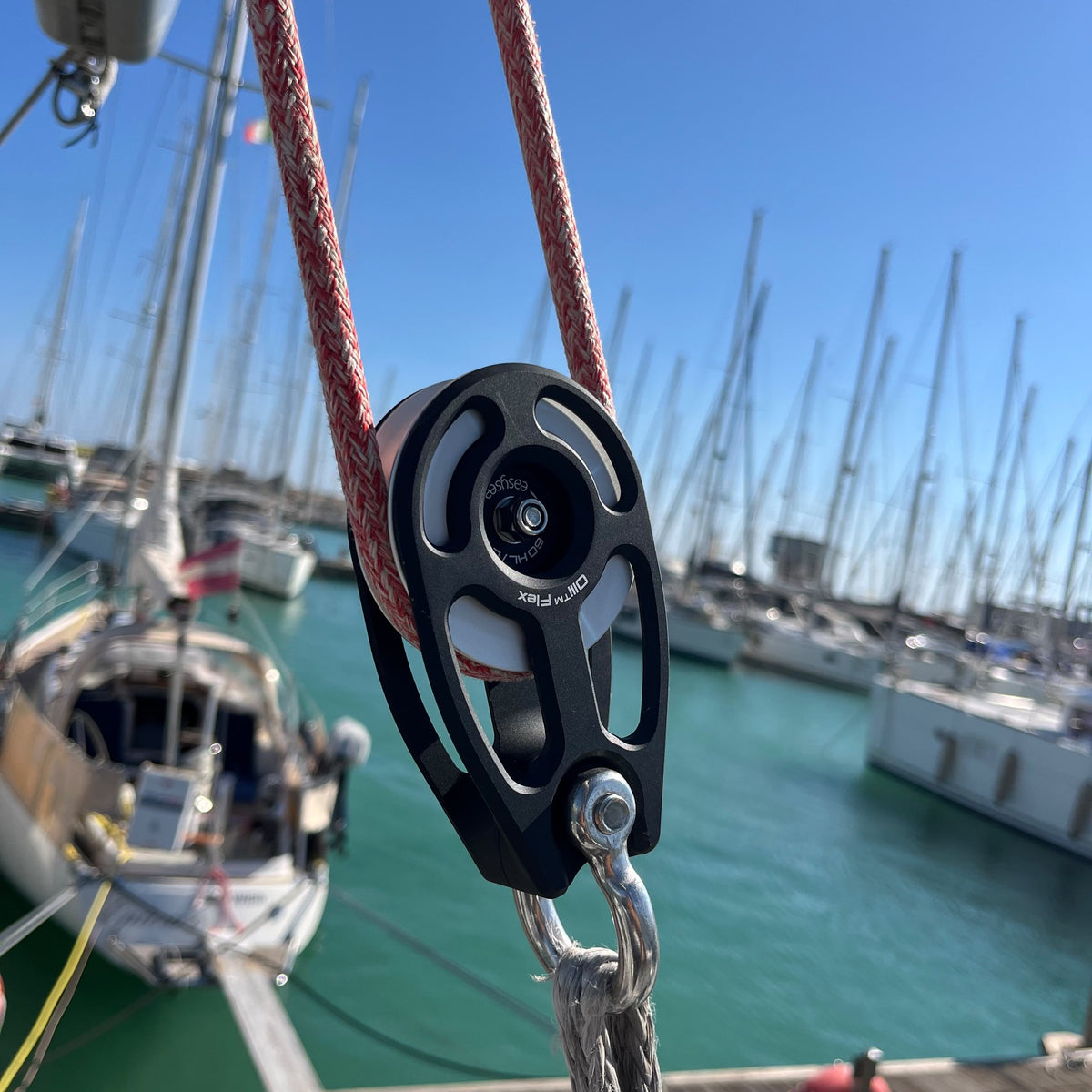 Olli Flex HL 60 L high load block with a red sheet running through, marina masts in the background